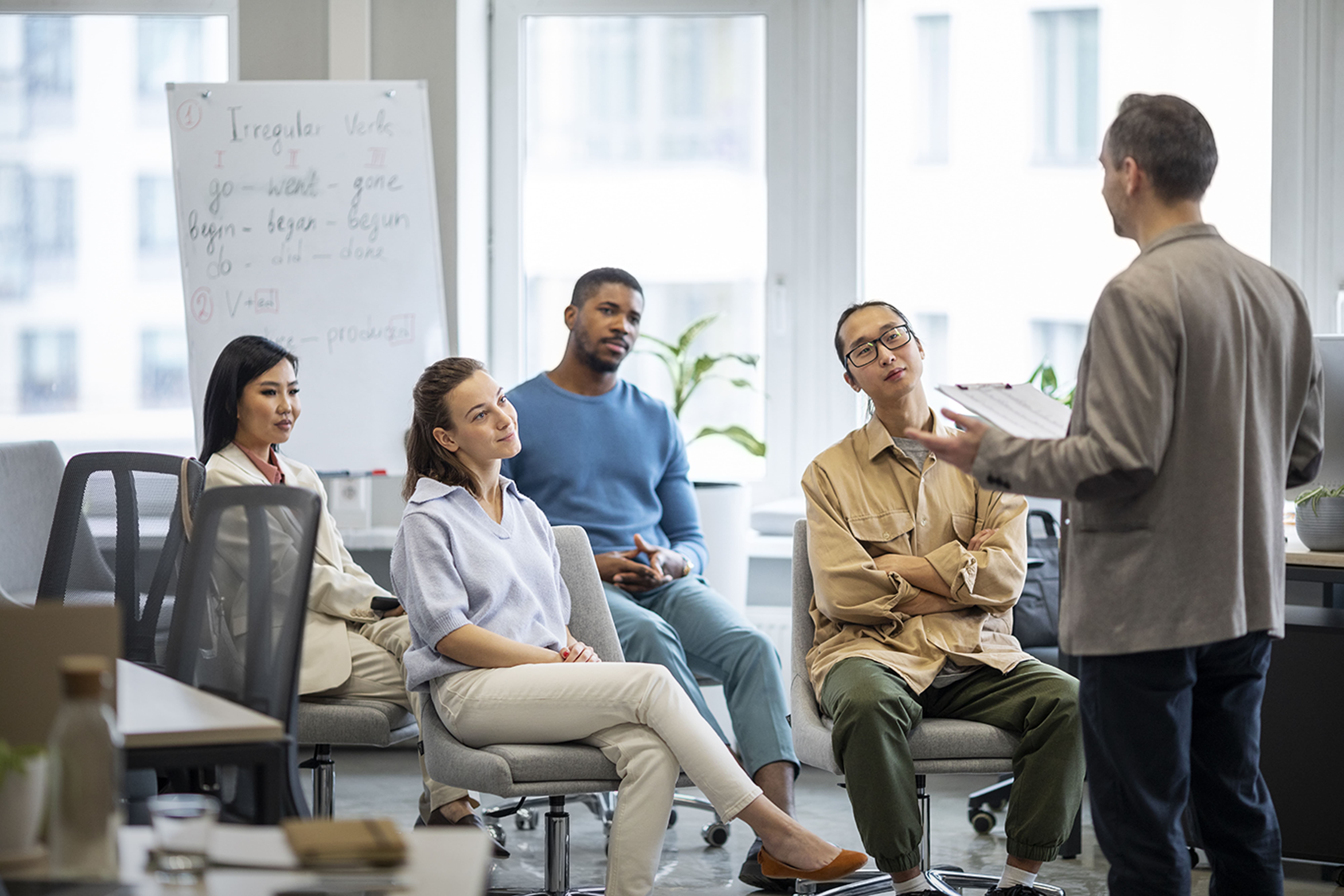 Facilitator mentoring a small group in a bright office workshop setting